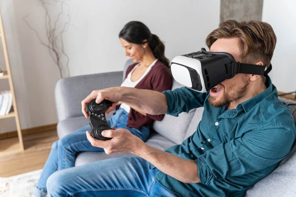 Man playing video games with virtual reality headset on couch